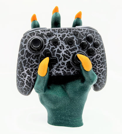 Monster Controller Stand holding a gaming controller with claws, featuring green glitter and orange claws for a spooky design.